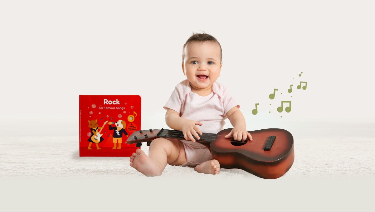 A girl is sitting on the floor and playing guitar. Musical activities, kids music, fun songs, kids music genres