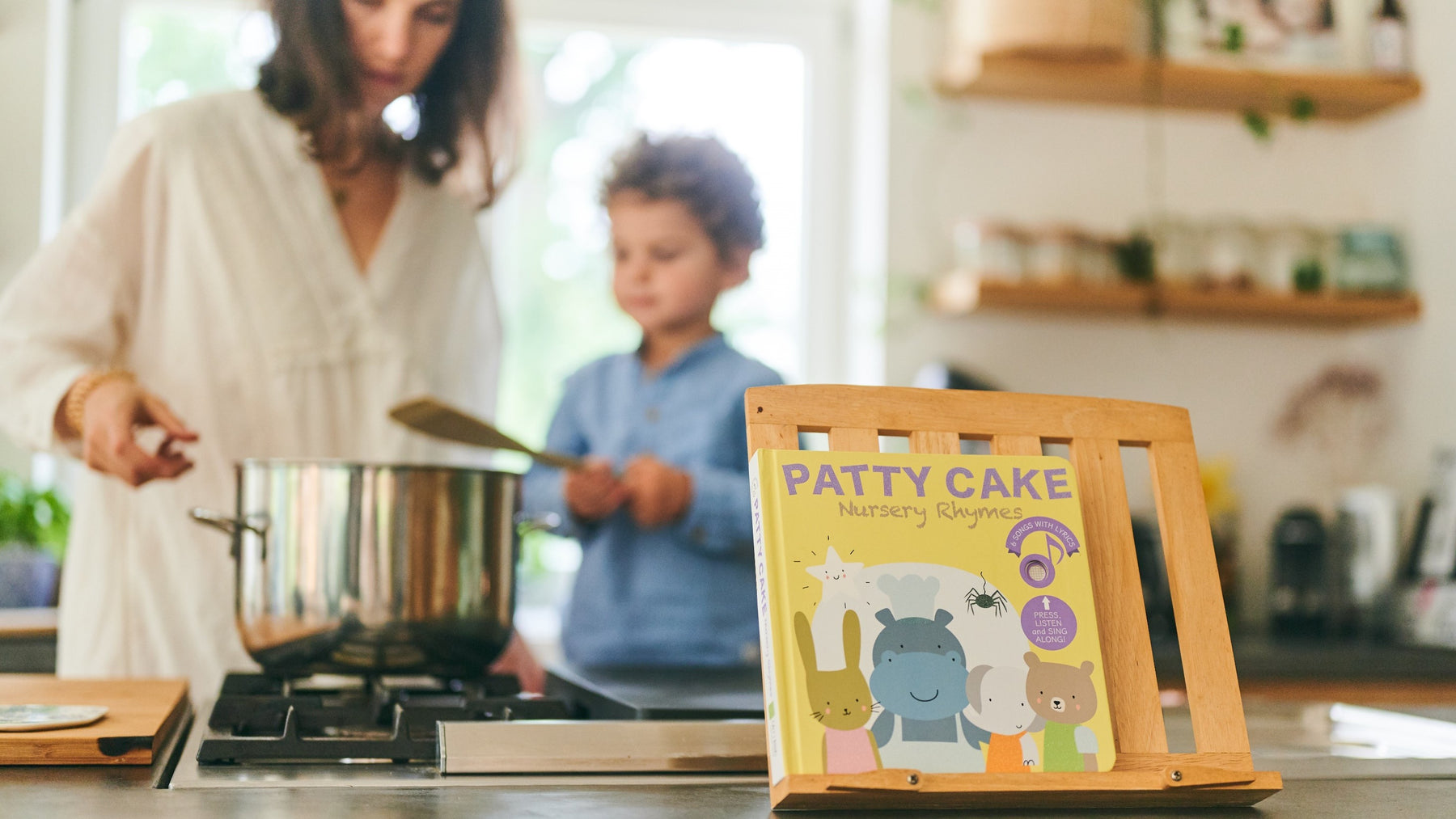 A Mom is reading and cooking with her young son. Children books, fun activities, educational.