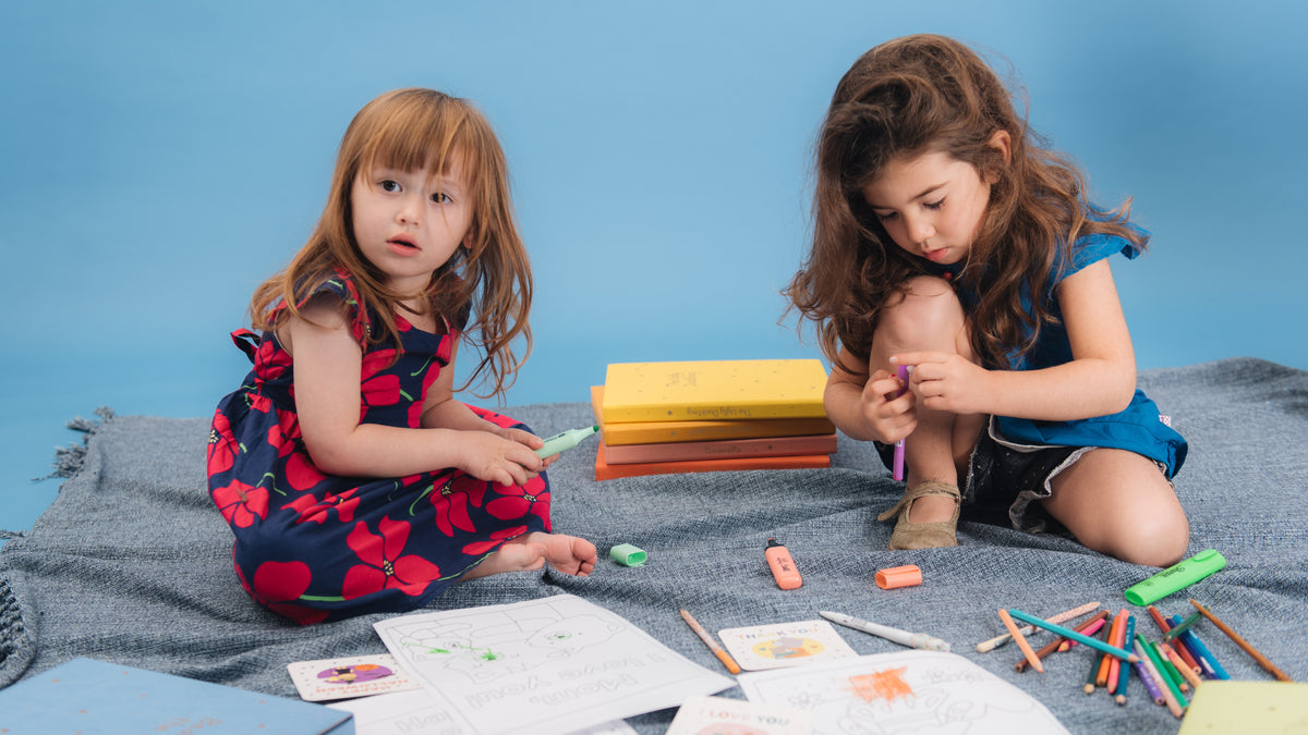Two toddler girls are drawing with colorful pens. Toddlers fun activities, sensory play, educational.