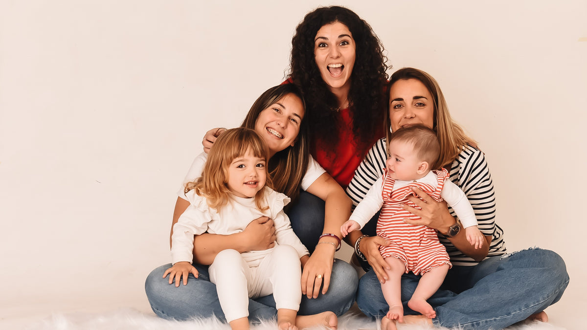 Three women are posing and laughing with two toddlers. Parenting hacks, kids activities, educational fun.