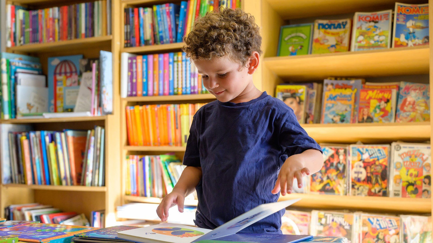 A boy is reading at a bookstore. toddler books, fun activities, educational