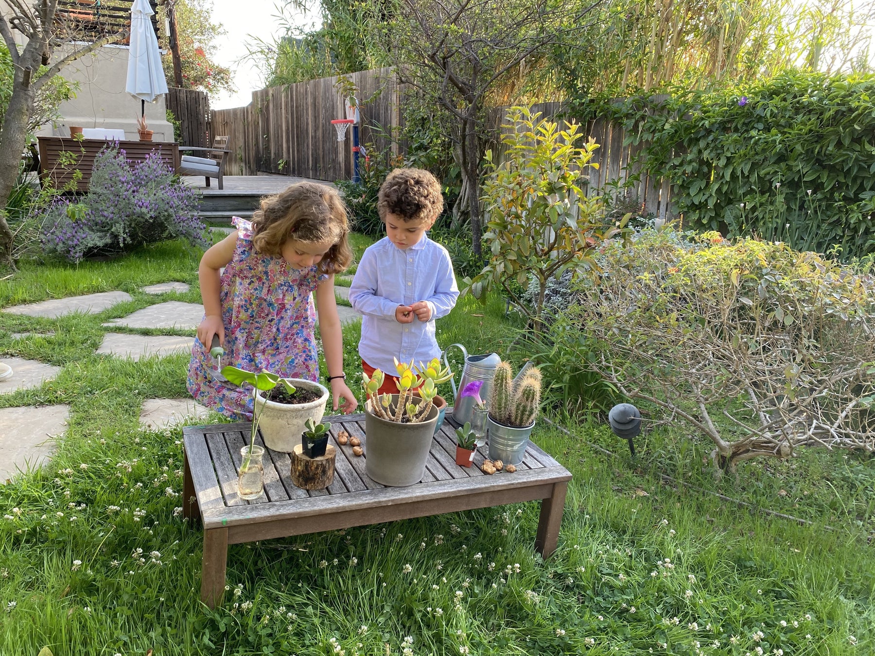 2 children planting flowers in honor of earth day.  Earth month, kids activities, outdoor kids activities 