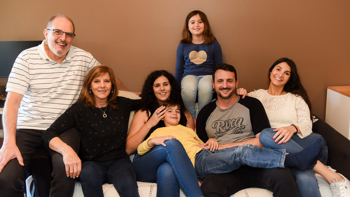  A large family of 7 is posing for a picture on the sofa. Parenting style, family activities, education.