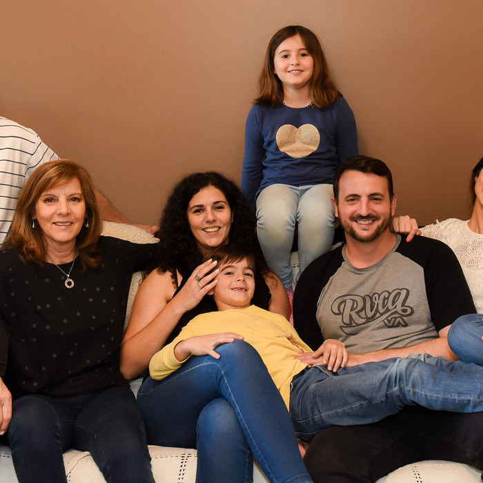  A large family of 7 is posing for a picture on the sofa. Parenting style, family activities, education.