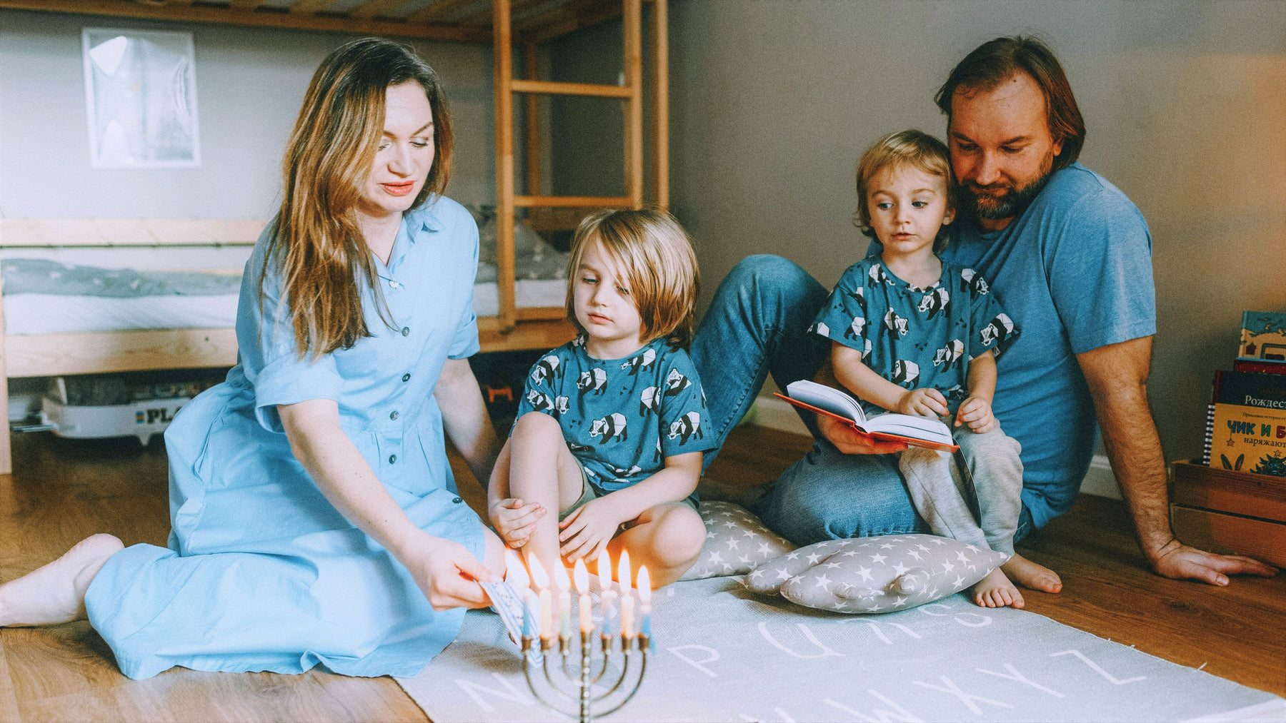 A Mom and a Dad are looking at a menorah with their two kids. Jewish activities for kids.